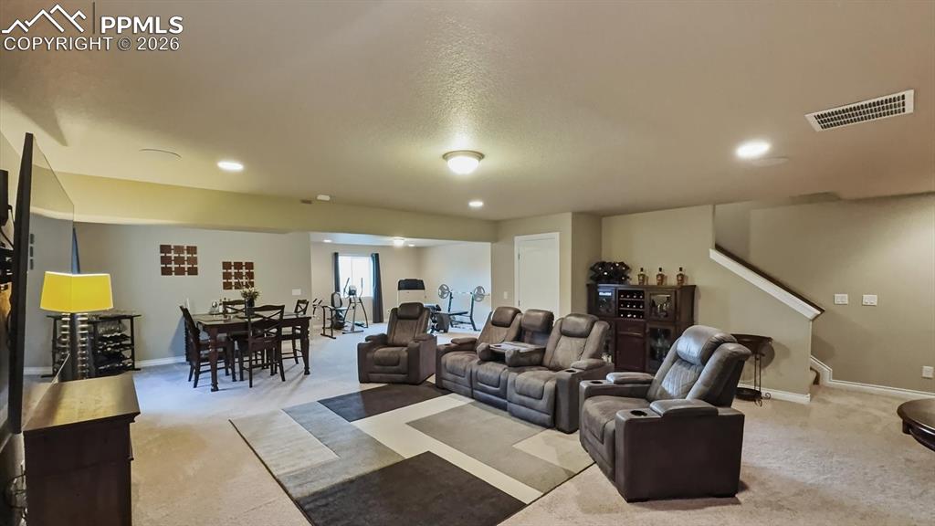 Image 37 of 50: Basement Family/Recreation Room with TV, Dining, and Exercise areas.