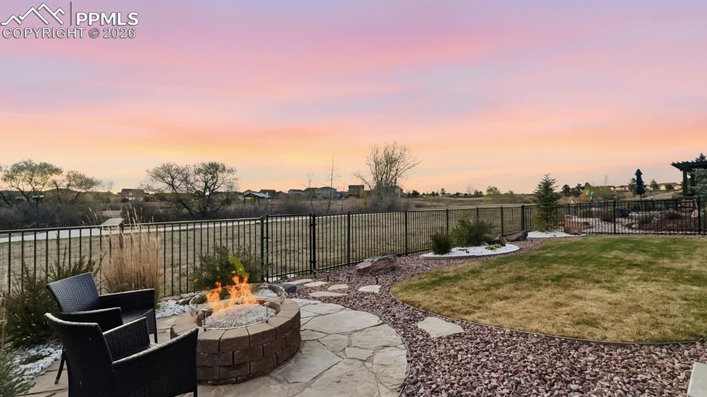 Image 48 of 50: Backyard flagstone patio with firepit and gas valve.