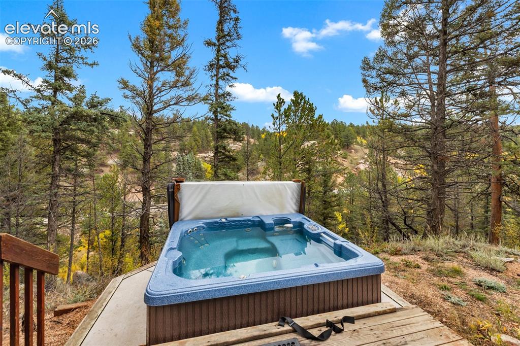 Image 11 of 50: Outdoor hot tub with wood paneling and a surrounding wood deck