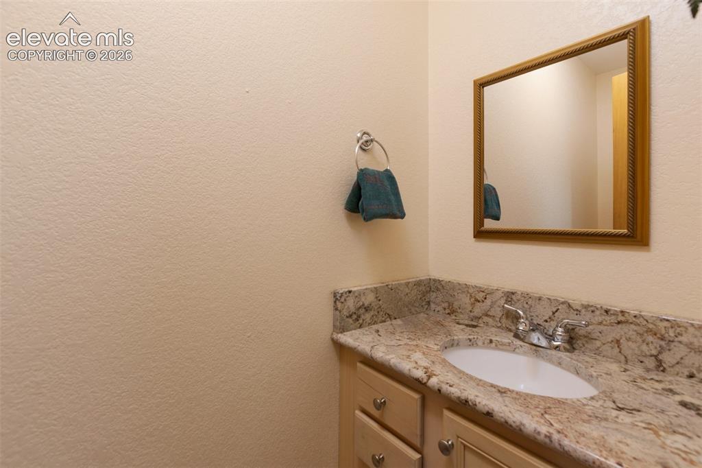 Image 26 of 50: Built-in vanity with light-toned cabinetry, an integrated sink, and a speck