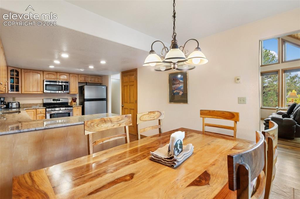 Image 28 of 50: Kitchen featuring wood cabinetry, stainless steel appliances, and granite c