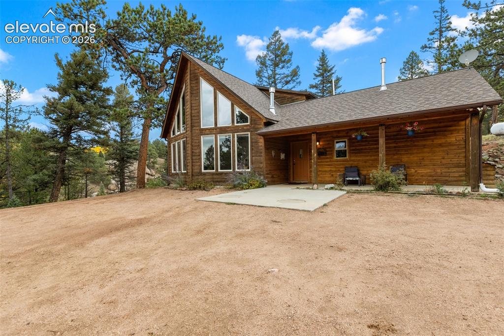 Image 3 of 50: Wood-sided A-frame structure with extensive window placements, an inviting