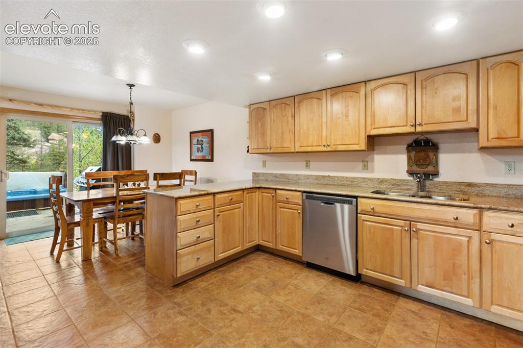 Image 31 of 50: Kitchen featuring light wood cabinetry, granite countertops, and a stainles