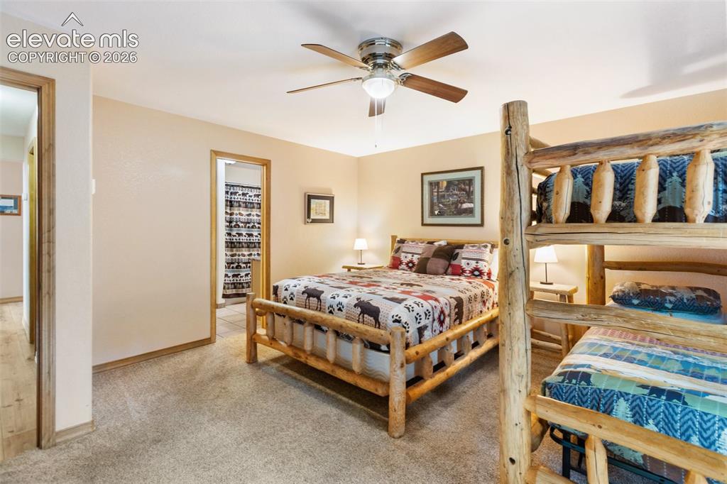 Image 33 of 50: Neutral tone wall color, carpeted flooring, wood-finish trim, ceiling fan, 