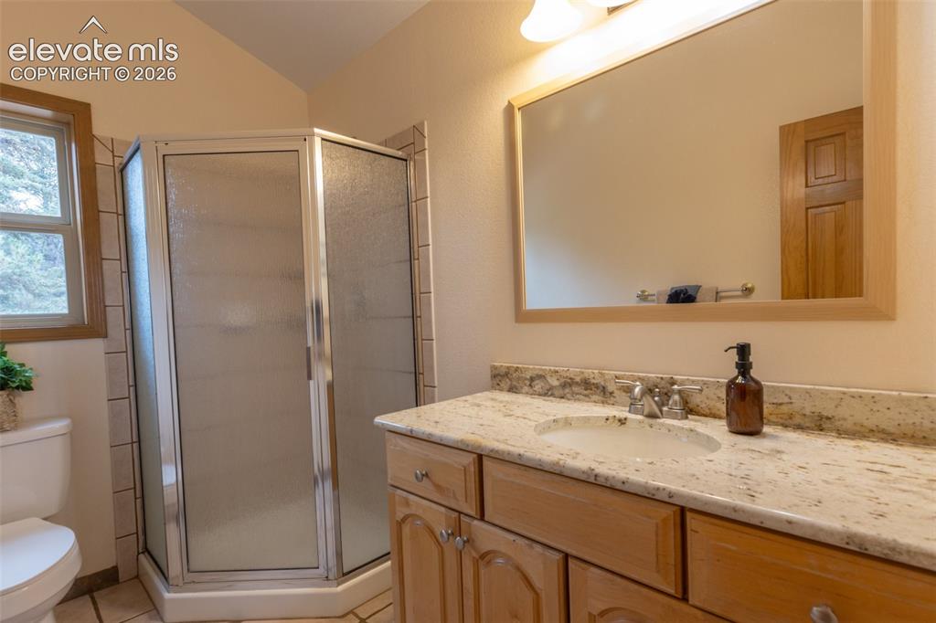 Image 37 of 50: Wood-finish vanity with an integrated sink and light-colored countertop