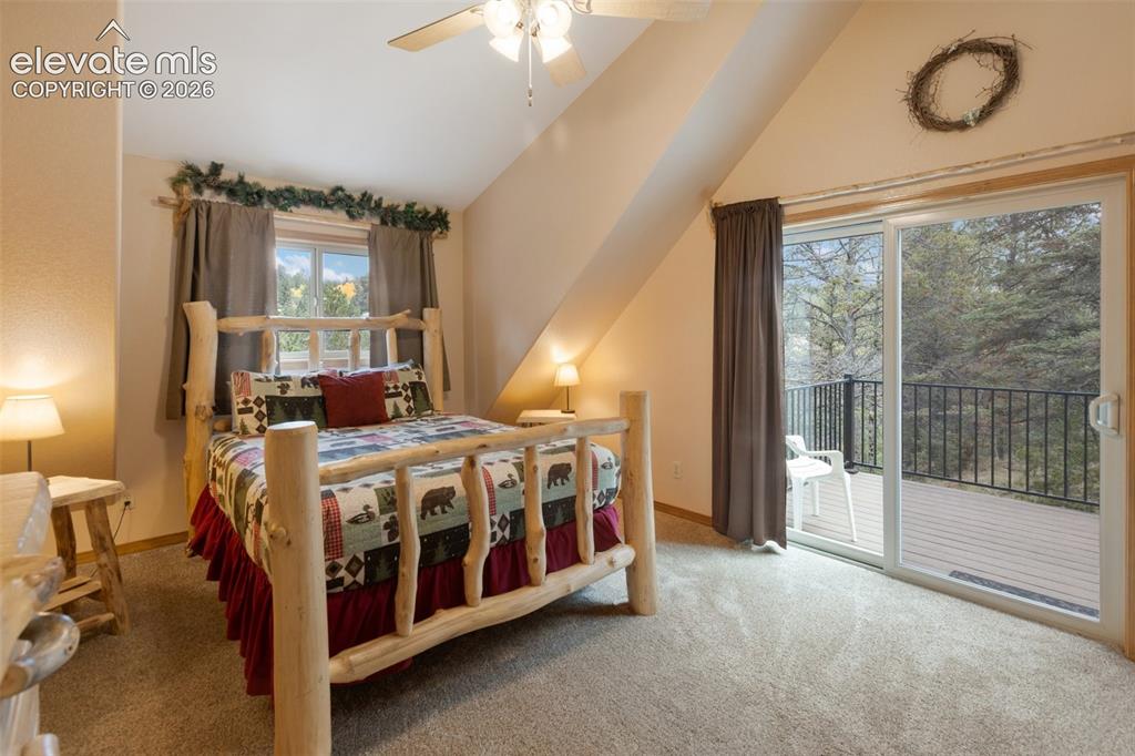 Image 39 of 50: Carpeted room with a ceiling fan, a window, and a sliding glass door openin