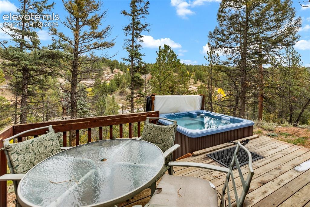Image 4 of 50: Expansive wooden deck with a built-in hot tub