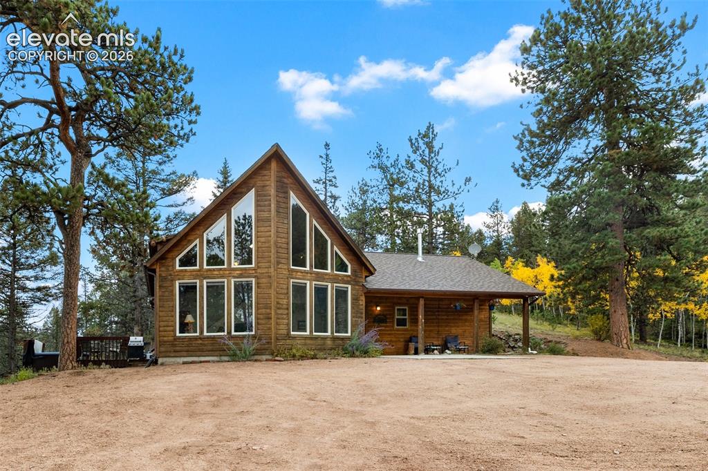 Image 43 of 50: Log cabin style exterior with a prominent A-frame window design