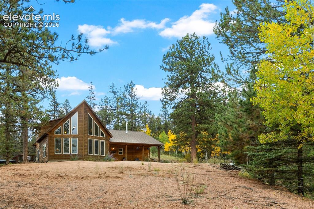 Image 46 of 50: Wood-sided residence with an A-frame architectural style