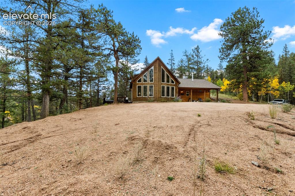 Image 47 of 50: Exterior featuring a gabled roofline, abundant window design, and a covered