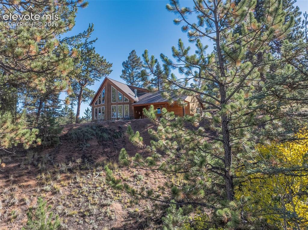 Image 9 of 50: Wood-sided home featuring a prominent A-frame architectural style