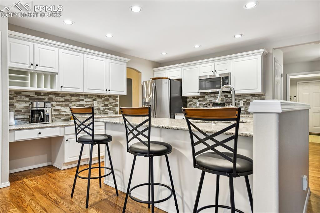 Image 12 of 47: Kitchen featuring stainless steel appliances, tasteful backsplash, white ca