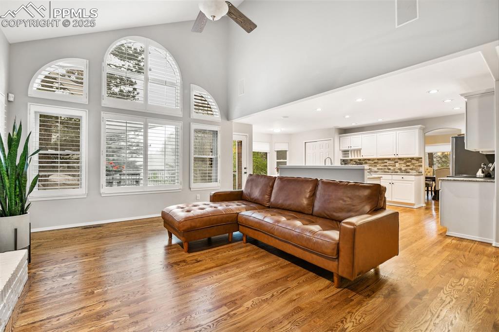 Image 14 of 47: Living room featuring light wood-style flooring, a ceiling fan, arched walk