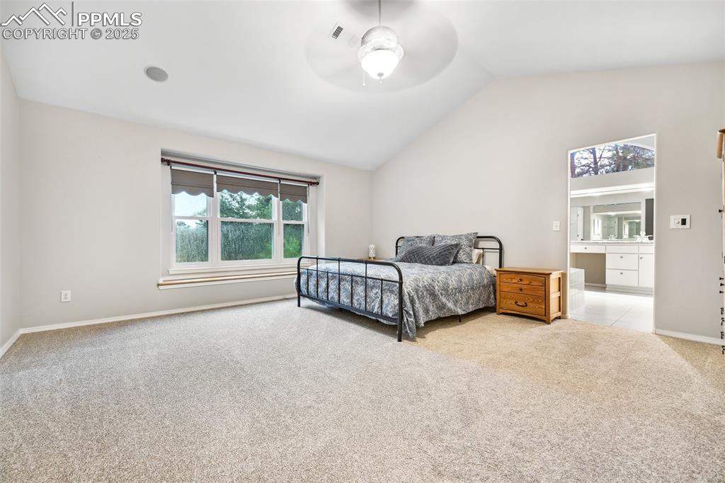 Image 20 of 47: Bedroom with light carpet, vaulted ceiling, ensuite bathroom, and a ceiling