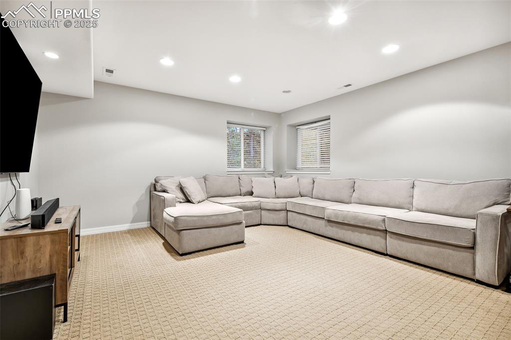 Image 30 of 47: Living room with recessed lighting and light carpet