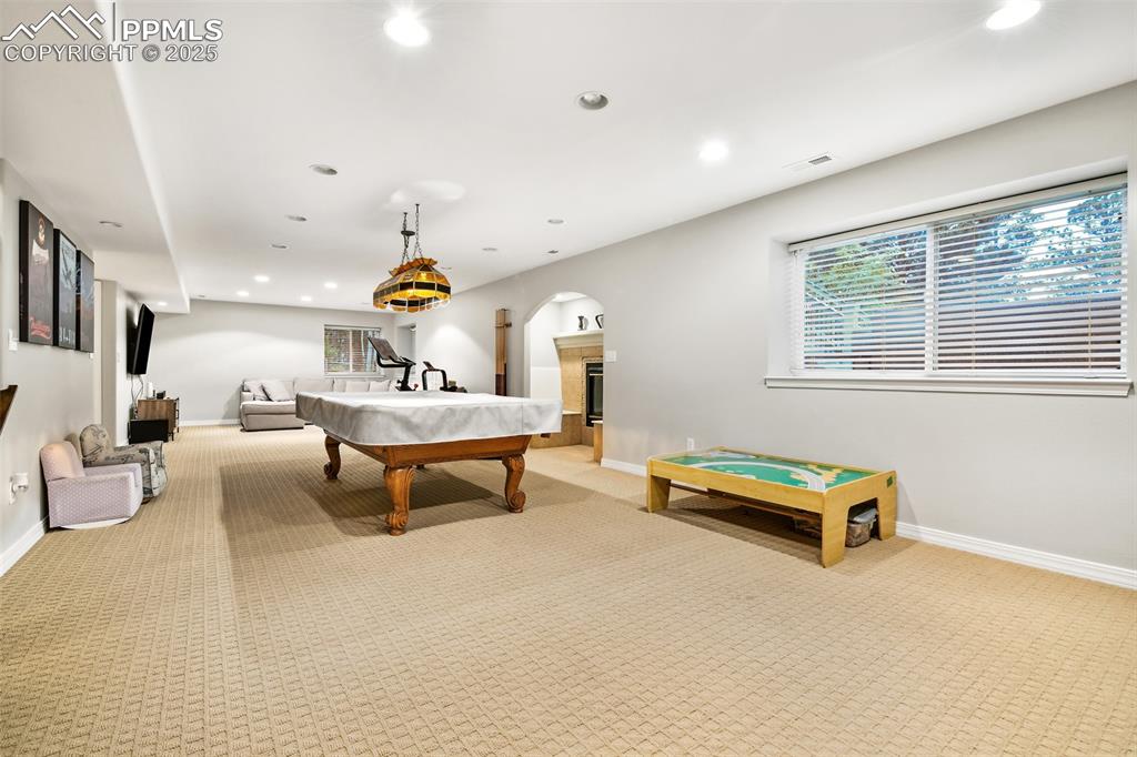 Image 32 of 47: Playroom with light carpet, billiards table, recessed lighting, and arched 