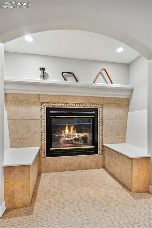 Image 35 of 47: Detailed view of a tile fireplace and recessed lighting