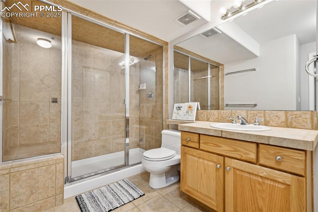 Image 37 of 47: Full bath with vanity, a stall shower, and tile patterned floors
