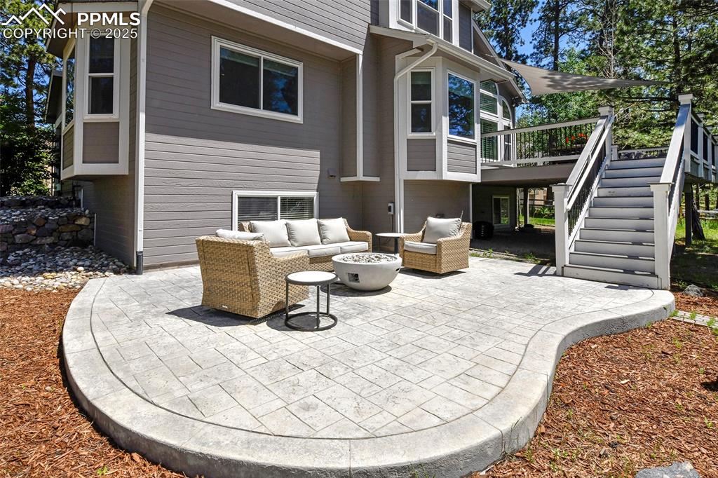 Image 44 of 47: View of patio with stairs, an outdoor living space with a fire pit, and a d