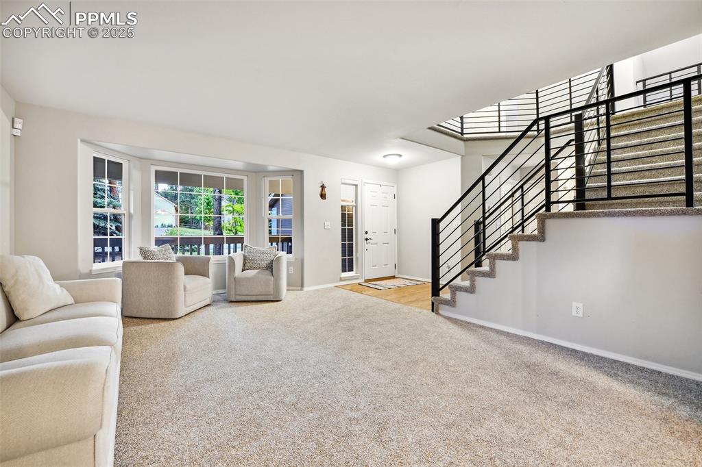 Image 5 of 47: Carpeted living area with stairs