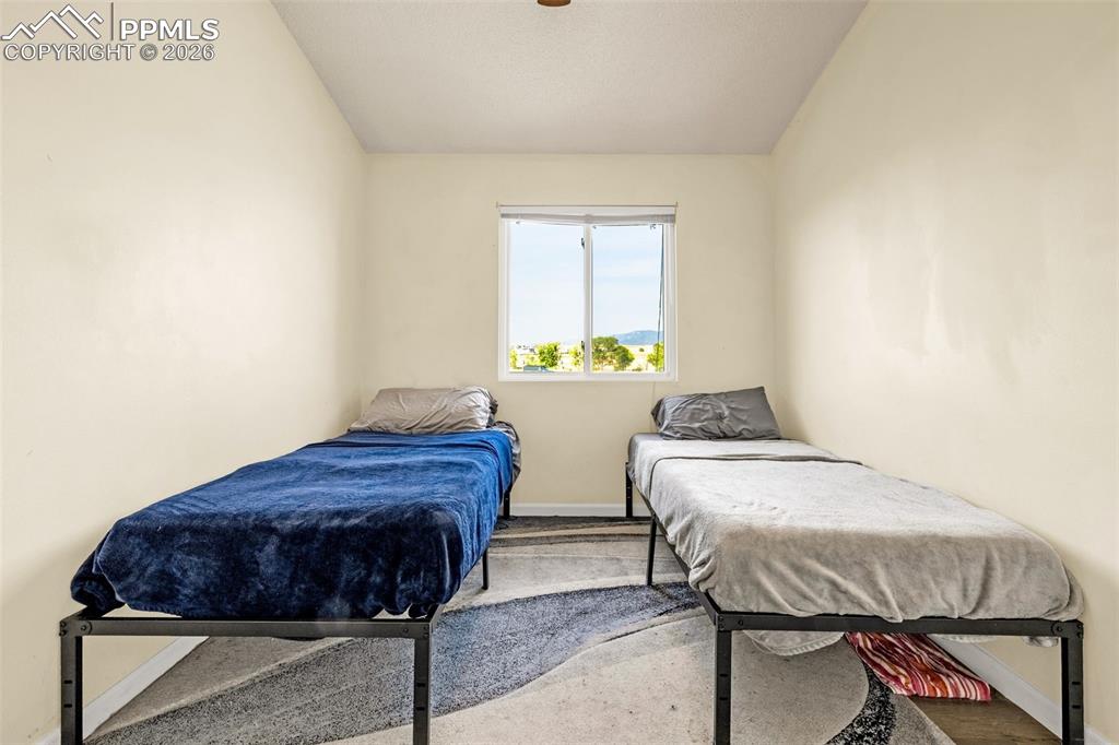 Image 18 of 30: Bedroom featuring vaulted ceiling and ceiling fan