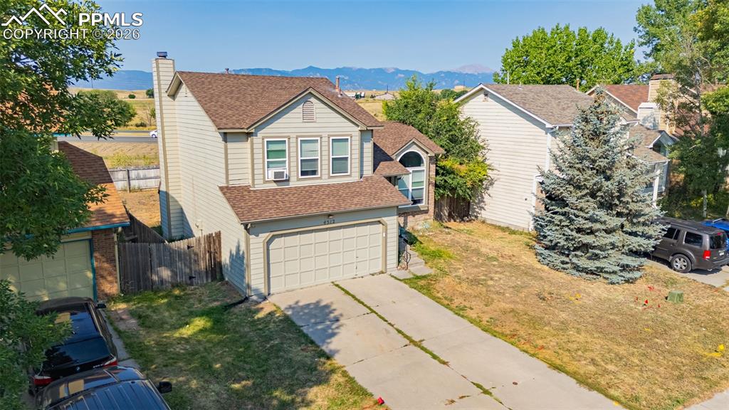 Image 29 of 30: View of front of home featuring a shingled roof, a mountain view, a garage,