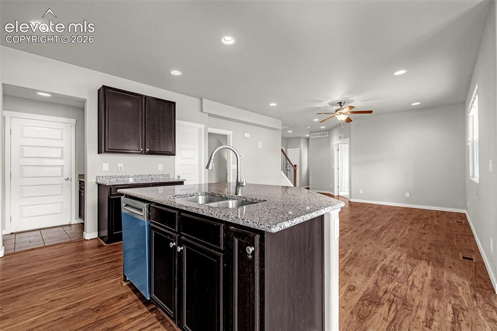 Image 10 of 44: Kitchen island with granite countertop, stainless steel sink, and gooseneck