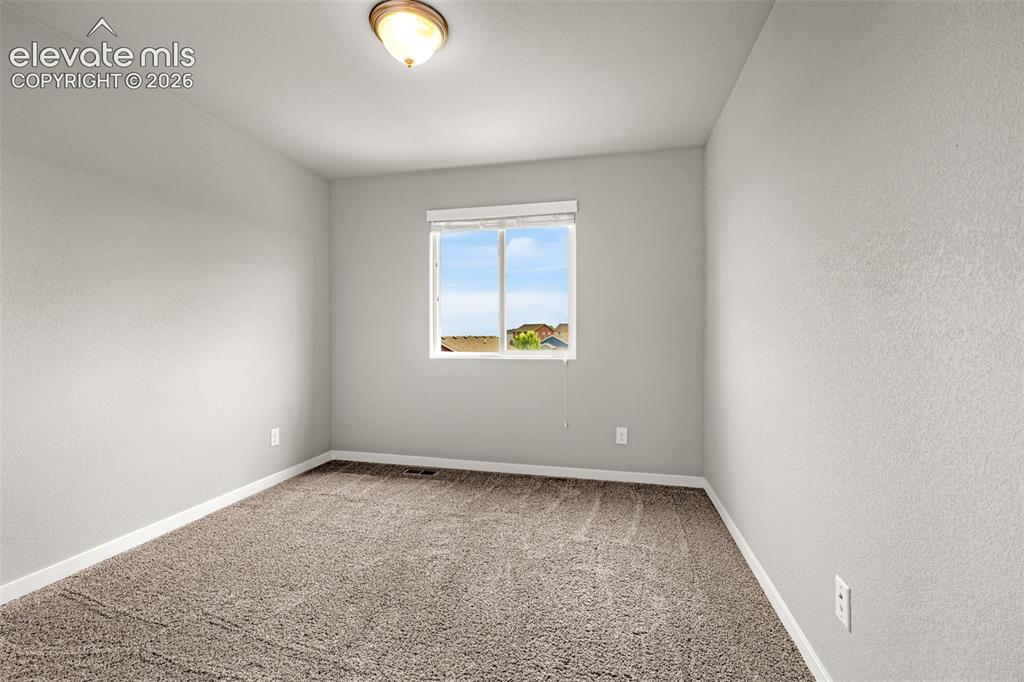 Image 16 of 44: Neutral wall paint, plush carpet flooring, and a single window with blinds
