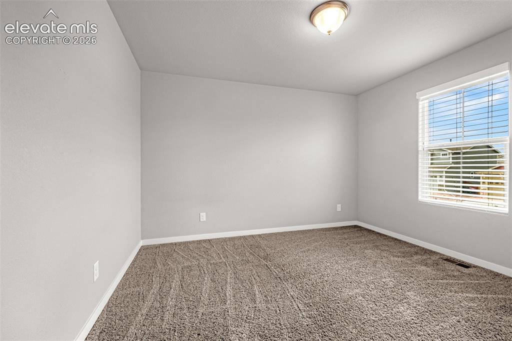 Image 20 of 44: Textured carpet flooring, neutral paint palette, flush mount ceiling light,