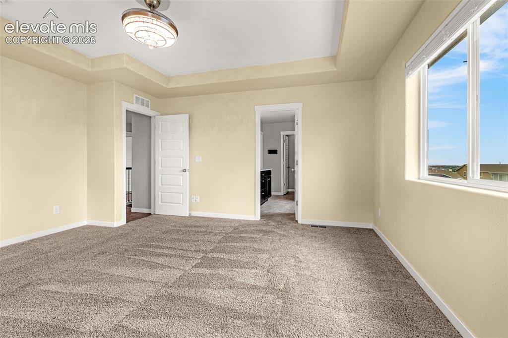 Image 24 of 44: Recessed ceiling details, carpeted flooring, and a decorative ceiling fixtu