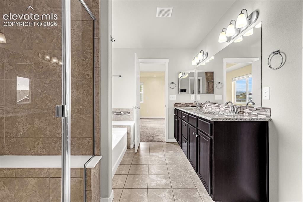 Image 27 of 44: Dual vanity with dark wood-finish cabinetry and light-colored countertops