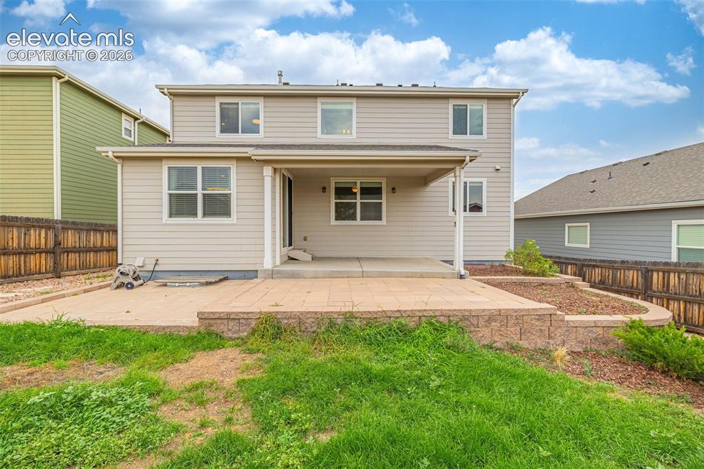 Image 32 of 44: Two-story exterior with horizontal siding, featuring a covered patio, an op