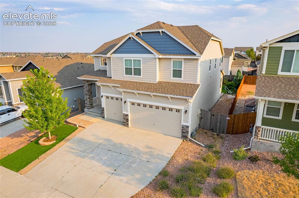 Image 37 of 44: Two-story residence featuring light-toned siding and blue accents