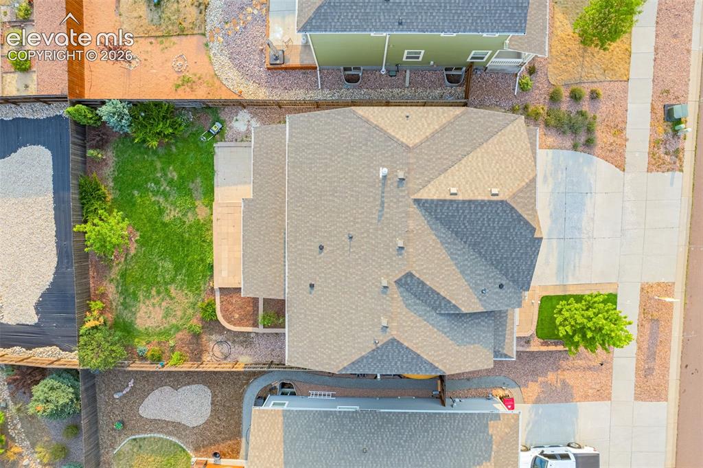 Image 39 of 44: Asphalt shingle roof, concrete driveway, concrete patio, grass lawn, and ma