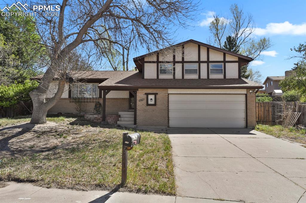 Caption: Split-level residence featuring a two-car garage with an overhead door