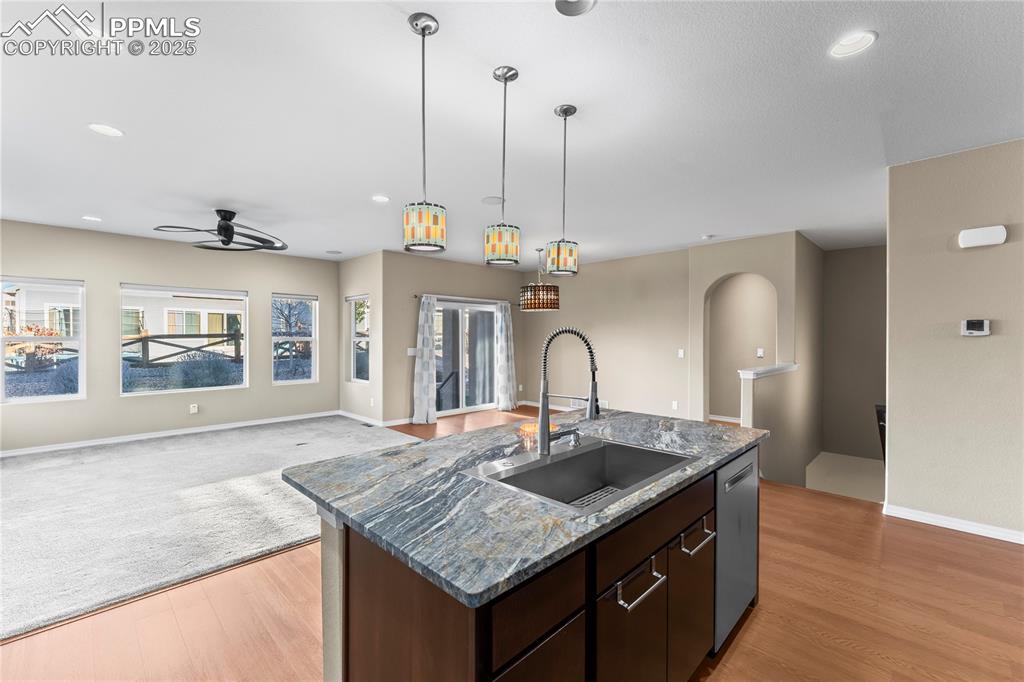 Image 12 of 45: Kitchen featuring dark brown cabinetry, open floor plan, recessed lighting,