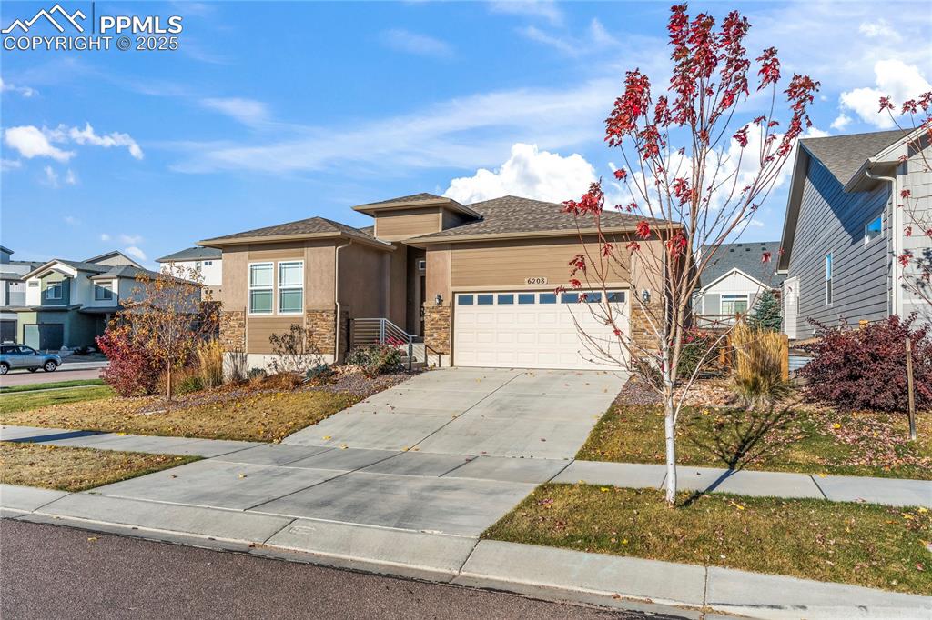 Image 2 of 45: View of front of home featuring driveway, an attached garage, stucco siding