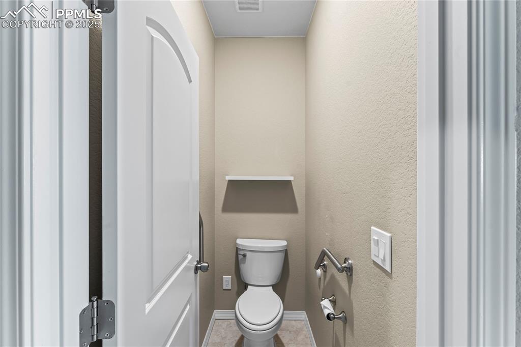 Image 23 of 45: Bathroom featuring a textured wall and tile patterned floors