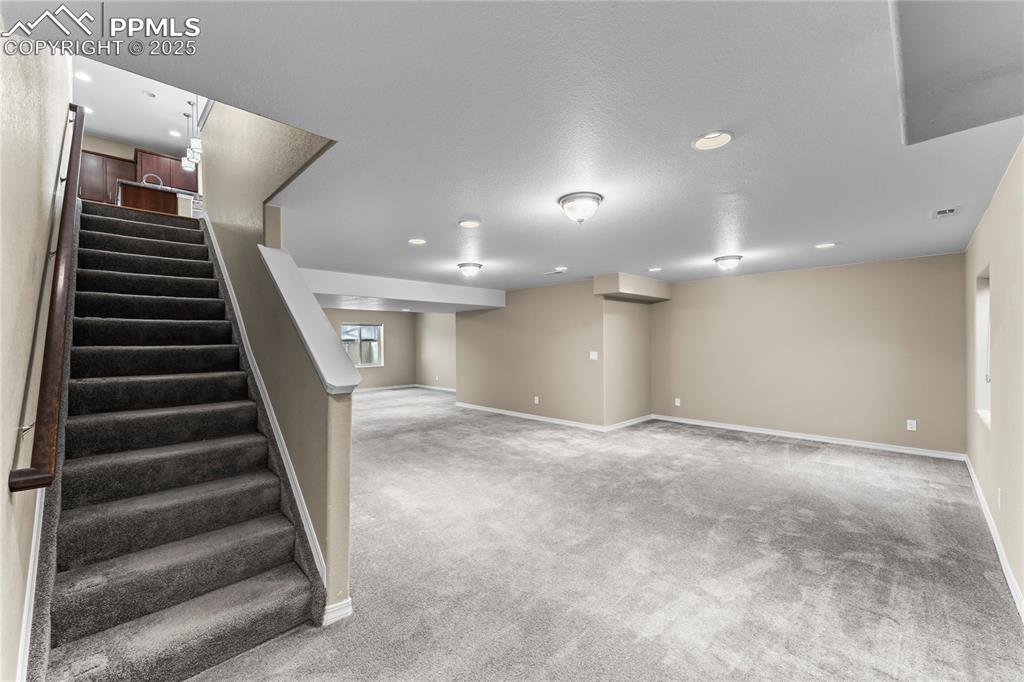 Image 25 of 45: Basement with carpet, stairway, and recessed lighting