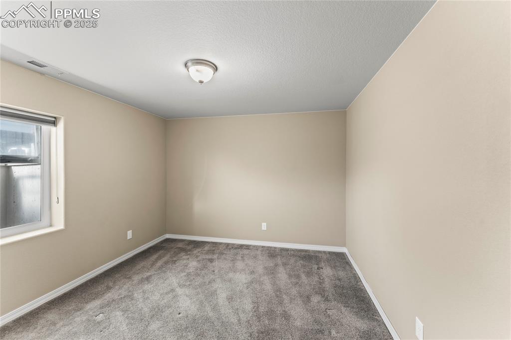 Image 32 of 45: Carpeted empty room featuring baseboards and a textured ceiling