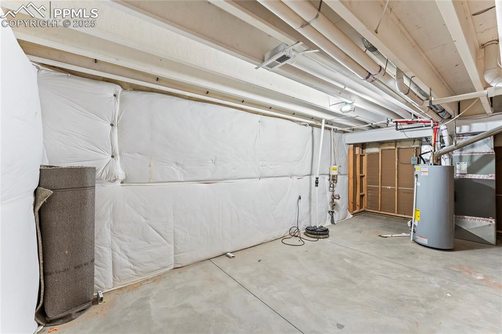 Image 36 of 45: Unfinished below grade area with water heater and heating unit