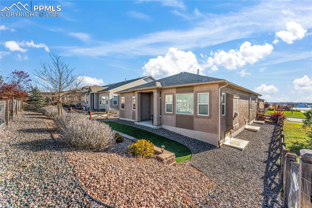 Image 38 of 45: View of front facade featuring a fenced backyard, roof with shingles, stucc