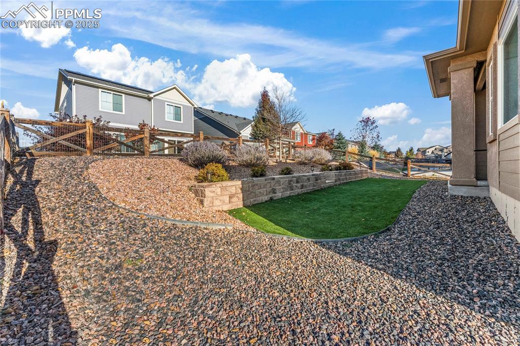 Image 40 of 45: Fenced backyard with a residential view
