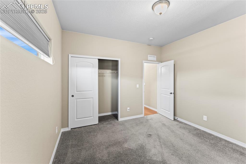 Image 9 of 45: Unfurnished bedroom with carpet floors, a closet, and a textured ceiling