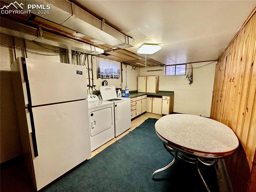Image 18 of 28: Laundry room with separate washer and dryer and cabinet space