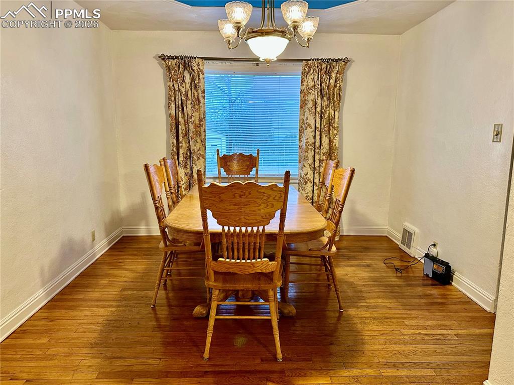 Image 6 of 28: Dining room featuring a chandelier and hardwood / wood-style flooring