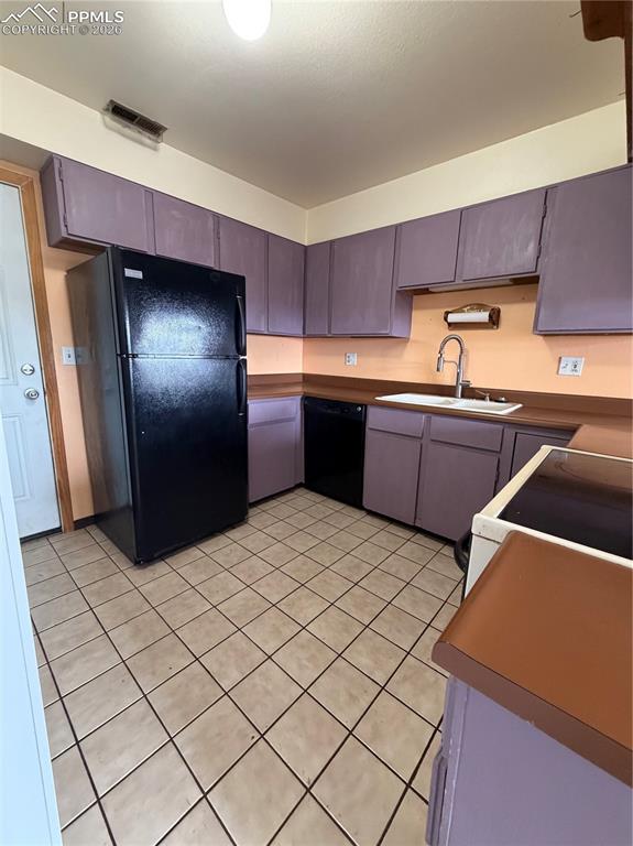 Image 5 of 12: Kitchen featuring purple cabinetry, light-toned backsplash, wood-finish cou