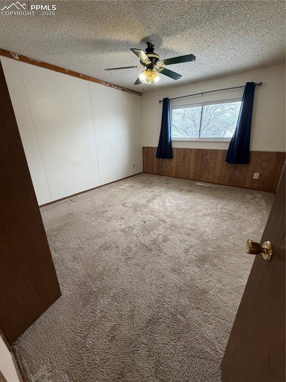 Image 8 of 12: Carpeted interior room featuring a ceiling fan with integrated lighting, wo