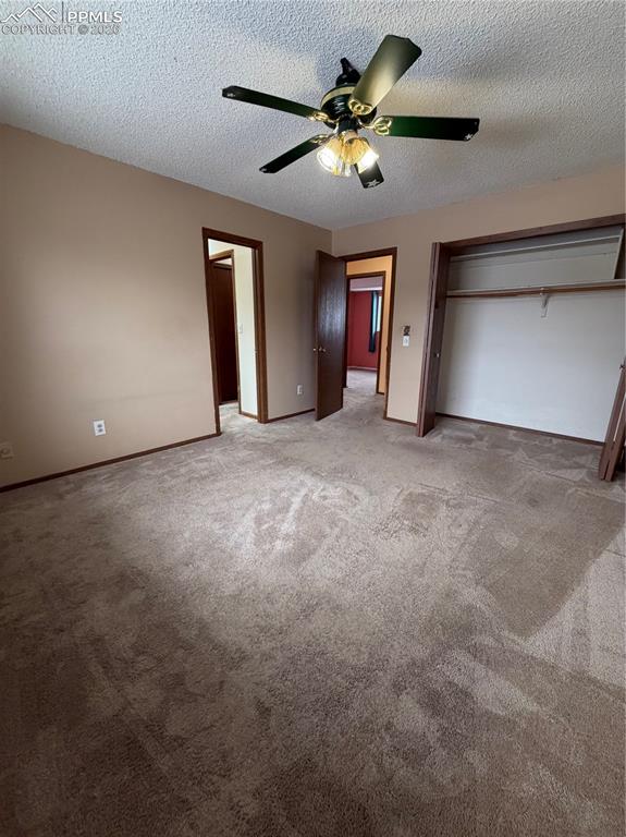 Image 9 of 12: Carpeted room featuring a ceiling fan with integrated lighting, wood-trim d