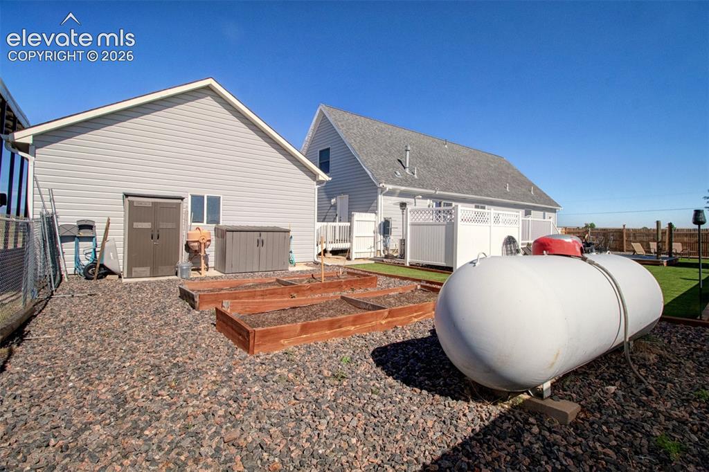 Image 29 of 43: Raised planters and large propane tank for extra energy